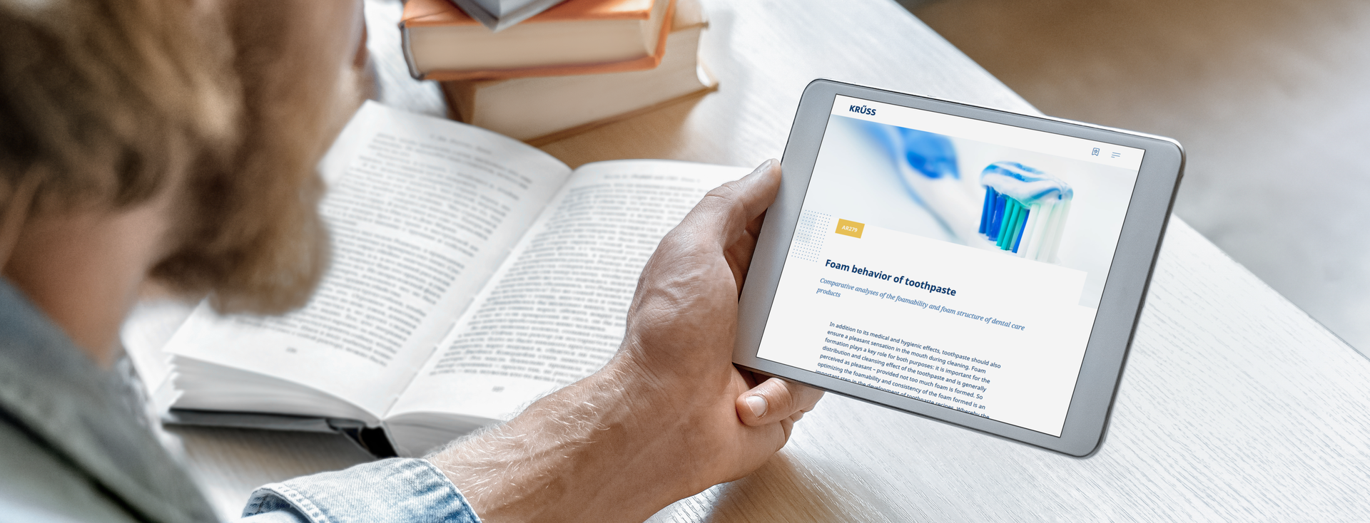 man taking notes while reading a KRÜSS article on a tablet