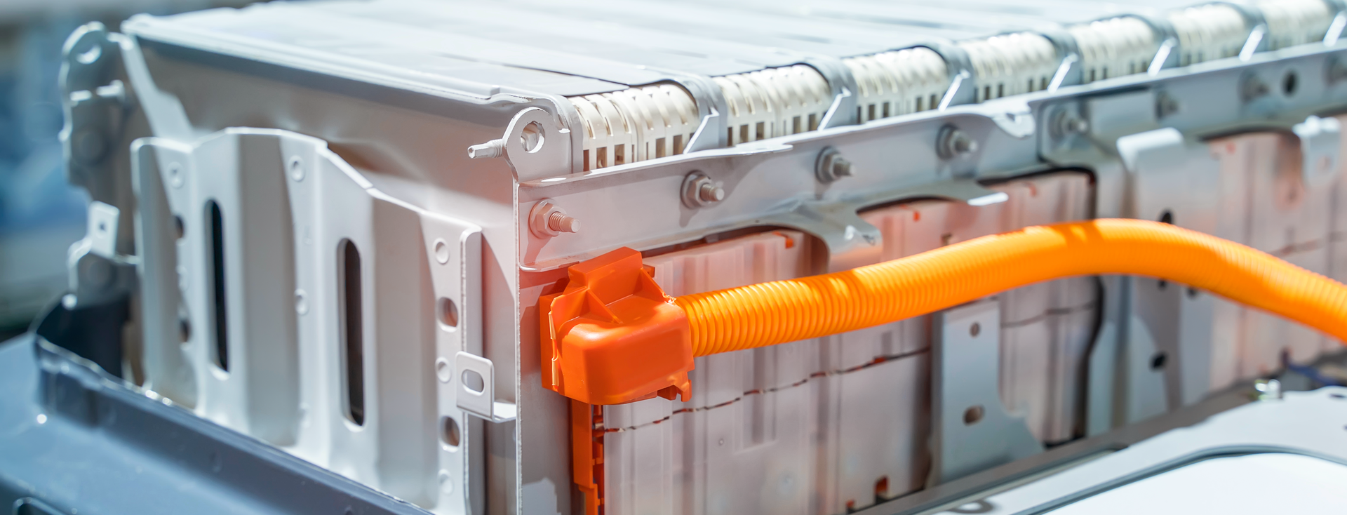 close-up of a large lithium-ion battery pack in an electric vehicle with an orange cable